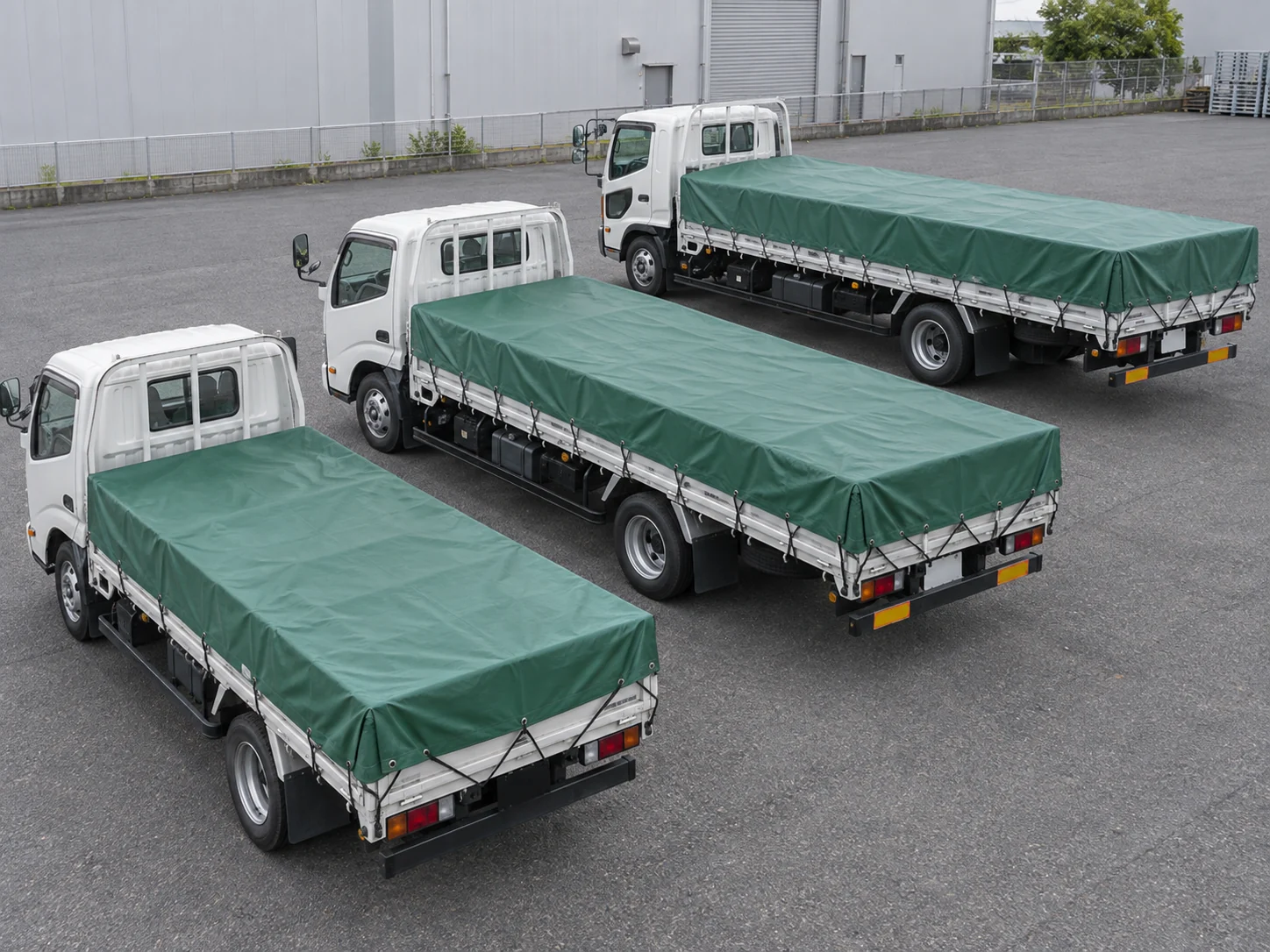 サイズの異なる3台の荷台を、それぞれの寸法のシートで覆った様子